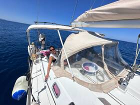 A woman enjoys a sunny day sailing on the open ocean, capturing the essence of adventure and relaxation on the water.