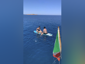 A couple enjoys paddleboarding in crystal-clear waters, capturing the essence of adventure and fun on the water.