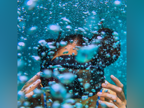 An underwater shot captures a snorkeler surrounded by bubbles, showcasing the vibrant marine experience — perfect for adventure seekers exploring the ocean depths.