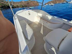 Interior view of a boat's seating area, showcasing comfortable cushions and a spacious layout, perfect for relaxing while enjoying the water.