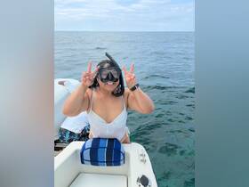 A joyful snorkeler poses with a peace sign while enjoying a day on the water, capturing the excitement of underwater adventures.
