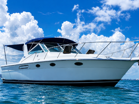 A stunning side view of a yacht cruising through clear waters under a bright blue sky, showcasing its sleek design and inviting atmosphere.