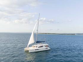 A stunning aerial view of a sleek catamaran sailing through calm waters, showcasing the perfect vessel for leisurely cruises or island hopping adventures.