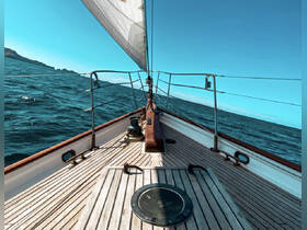 A stunning view from the deck of a sailboat, showcasing the vessel's elegant lines and the vibrant blue ocean as it sails through the water.