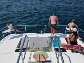 A family enjoys a sunny day on a boat, with one child sitting on the railing and others relaxing on the deck — perfect for summer adventures on the water.