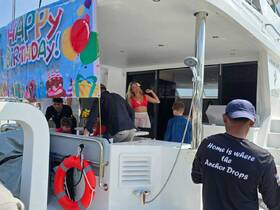 A lively birthday celebration aboard a boat, featuring guests enjoying the festivities with a colorful banner and decorations — perfect for unforgettable party experiences on the water.