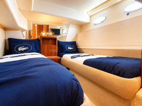 Cozy interior cabin of a boat featuring twin beds with stylish bedding, perfect for comfortable overnight stays while cruising.
