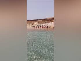 A group of friends enjoys a sunny day at the beach, relaxing by the water's edge — perfect for summer getaways and beach parties.