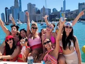 A lively group of friends celebrates on a boat in Chicago, enjoying drinks and the vibrant city skyline — perfect for a fun day out on the water.