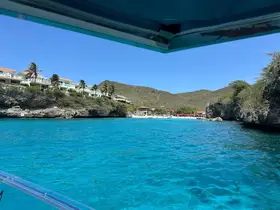 A stunning view of a coastline with turquoise waters and lush hills, perfect for showcasing the beauty of a tropical getaway.