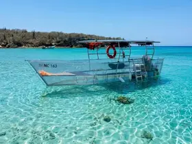 A clear view of a boat anchored in pristine turquoise waters, showcasing the serene beauty of the surrounding landscape.