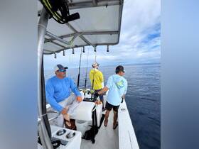 A group of friends enjoys a fishing trip on the open ocean, showcasing camaraderie and adventure on the water.