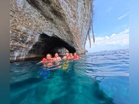 A group of friends enjoys a snorkeling adventure in a stunning cave, showcasing the beauty of the underwater world and the thrill of exploration.