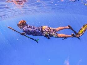 A snorkeler explores the vibrant underwater world, showcasing the thrill of diving and marine adventure in crystal-clear waters.