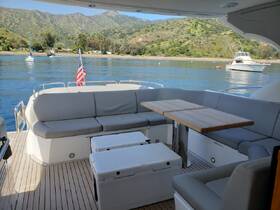 A spacious and stylish interior seating area on a boat, featuring comfortable lounge seating and a dining table, perfect for relaxing or enjoying meals while on the water.