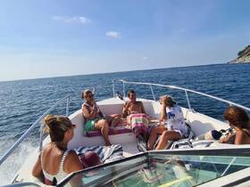 A lively group enjoys a sunny day on the boat, relaxing and soaking up the sun — perfect for a fun day out on the water.