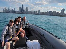 A family enjoys a boat ride on the water with the stunning Chicago skyline in the background — perfect for city exploration and memorable experiences.