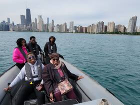 A joyful group enjoys a boat ride with the stunning Chicago skyline in the background, perfect for family outings and city explorations on the water.
