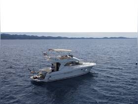 Aerial view of a yacht cruising through open waters, showcasing its sleek design and fishing gear — perfect for a day of adventure at sea.