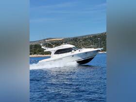 A sleek speedboat glides through the water, showcasing its dynamic design and performance on a sunny day.