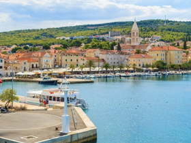 A picturesque view of a harbor with colorful buildings and boats, showcasing the charm of coastal life — perfect for exploring island destinations.