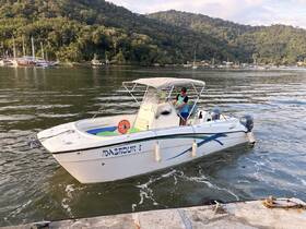 A person operates a boat named 'Mabrouk I' as it navigates through calm waters, surrounded by lush greenery and scenic views — perfect for a day on the water.