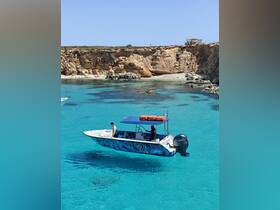 A small boat navigates through crystal-clear turquoise waters, with passengers enjoying the scenic beauty — a perfect setting for exploration and adventure.