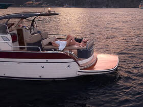 Two guests relax on the deck of a yacht during sunset, enjoying a serene moment on the water — perfect for unwinding after a day of adventure.
