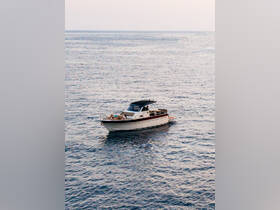 A boat glides through calm waters with guests relaxing on deck, perfect for enjoying a serene day on the water.