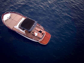 A couple enjoys cocktails on a stylish boat, surrounded by tranquil waters — an ideal setting for relaxation and romantic moments on the water.
