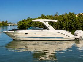 A sleek speedboat glides through calm waters, showcasing its elegant design against a backdrop of lush greenery — perfect for leisurely outings or water adventures.