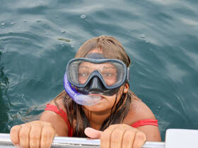 A young girl enjoys snorkeling in clear waters, showcasing the excitement of underwater exploration — a perfect moment for family adventures on the water.