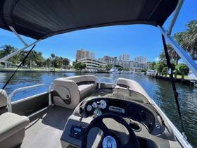 A view of the helm and seating area inside a pontoon boat, showcasing a comfortable and stylish interior perfect for leisurely outings on the water.