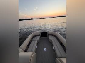 A spacious interior view of a pontoon boat featuring comfortable seating, perfect for relaxing while enjoying scenic water views at sunset.