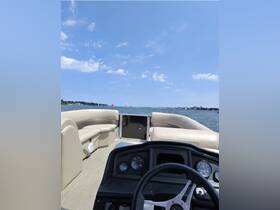 A view of the helm and seating area inside a pontoon boat, showcasing the spacious and comfortable interior, perfect for leisurely outings on the water.