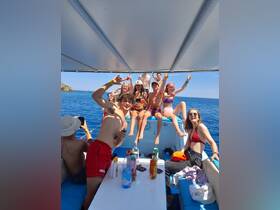 A lively group of friends enjoys a fun day on the water, celebrating with drinks and laughter aboard a boat — perfect for summer adventures and unforgettable memories.