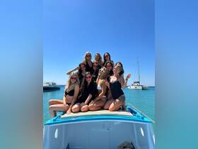 A lively group of friends celebrates on the deck of a boat, enjoying a sunny day on the water — perfect for summer parties and memorable outings.