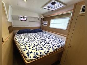 Cozy cabin interior featuring a comfortable bed with floral bedding, perfect for relaxing on a boat getaway.