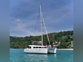 A stunning catamaran anchored in clear turquoise waters, surrounded by lush greenery and beachside resorts, perfect for a relaxing day on the water.