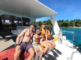 A family enjoys a fun snorkeling adventure on a boat, showcasing excitement and togetherness in a beautiful marine setting.