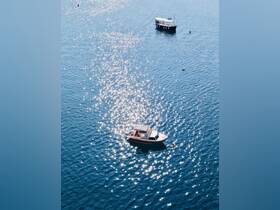 Aerial view of two boats gliding over sparkling blue waters, showcasing the serene beauty of a day on the water.