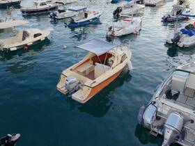 A serene view of a small boat docked among others in a marina, showcasing its sleek design and tranquil waters.