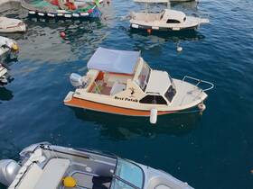 A picturesque view of the 'Brzi Patak' boat docked in a serene harbor, surrounded by other vessels, showcasing the charm of boating life.