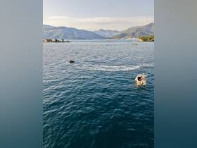 A scenic view of two boats navigating the tranquil waters, with mountains in the background, showcasing the beauty of outdoor adventures.