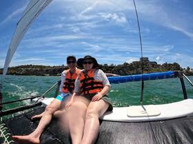 A couple enjoys a sunny sailing adventure on the ocean, showcasing the thrill of being out on the water together.