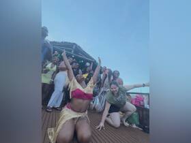 A vibrant group of friends celebrates with dancing on a boat, capturing the essence of a lively party atmosphere on the water.