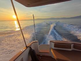 A stunning sunset view from the deck of a boat, showcasing the tranquil waters and wake as the vessel cruises along, perfect for evening excursions.