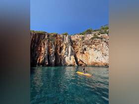 A kayaker navigates the crystal-clear waters near stunning cliffs, showcasing the beauty of outdoor adventures and scenic landscapes.