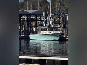 A sleek boat docked at the marina, showcasing its vibrant turquoise hull against the calm waters — perfect for fishing or leisure outings.