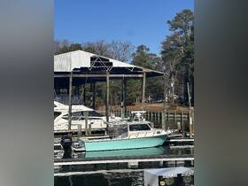 A charming boat docked at a marina, showcasing its sleek design against a backdrop of clear blue skies and surrounding greenery.